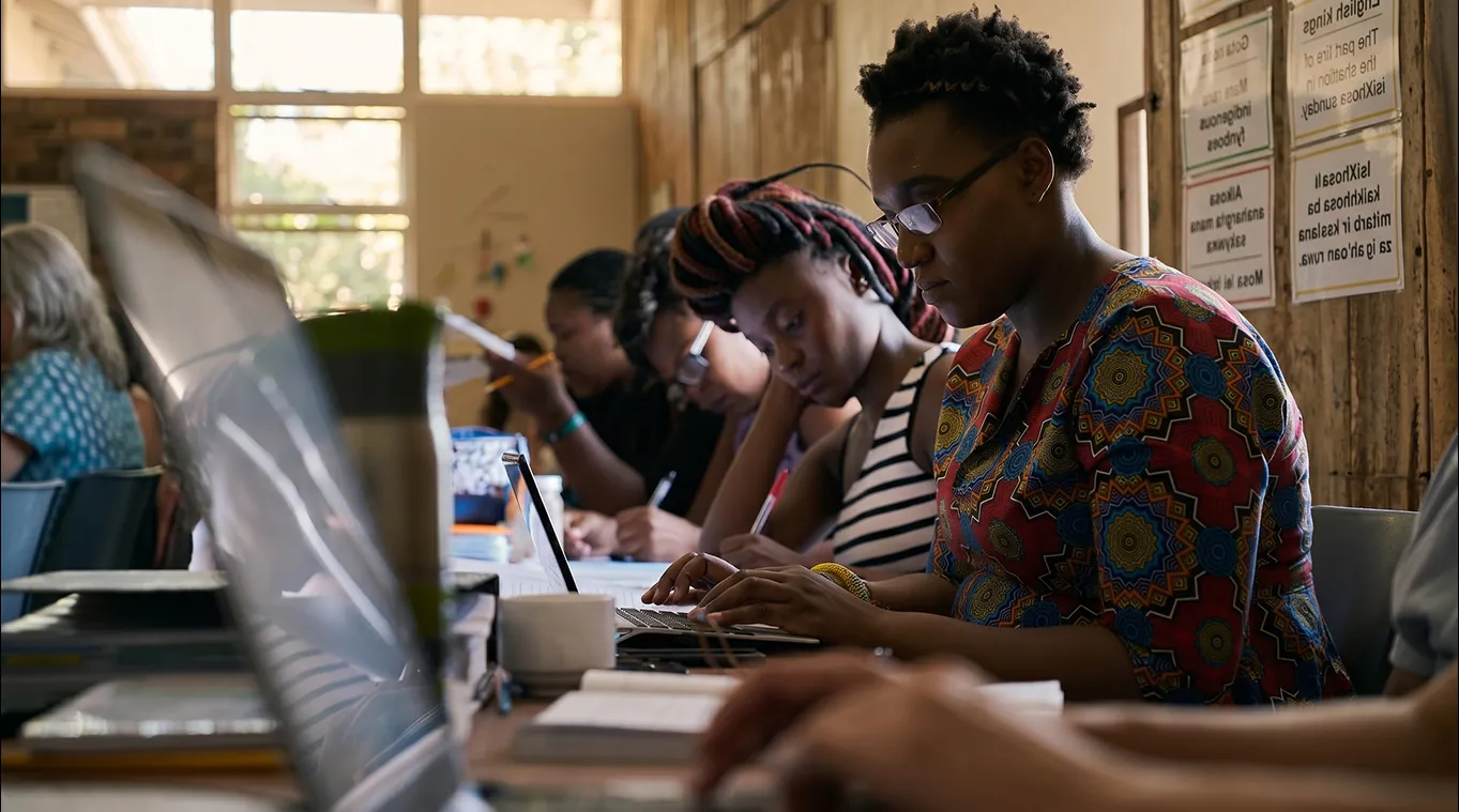 Adults studying with laptops and notebooks