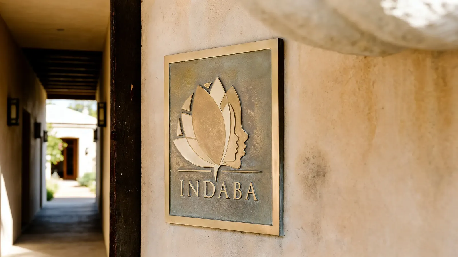 Concept illustration: Indaba emblem mounted on a warm interior wall